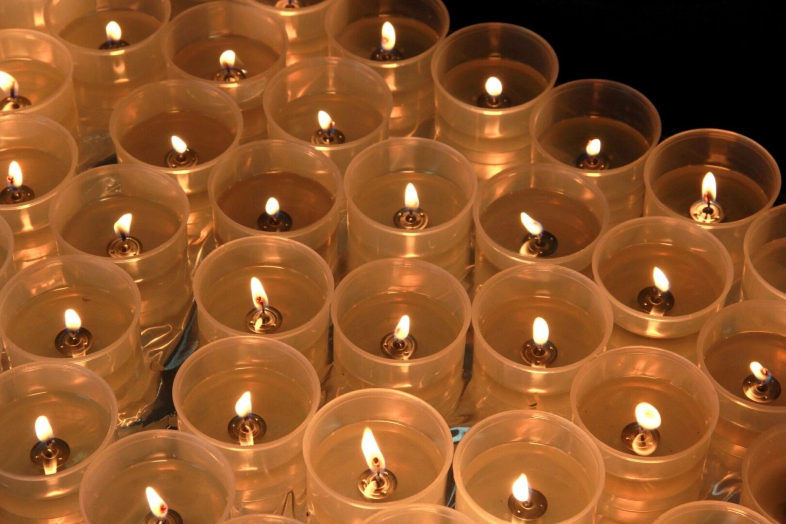 A bunch of lit candles sitting on top of each other.